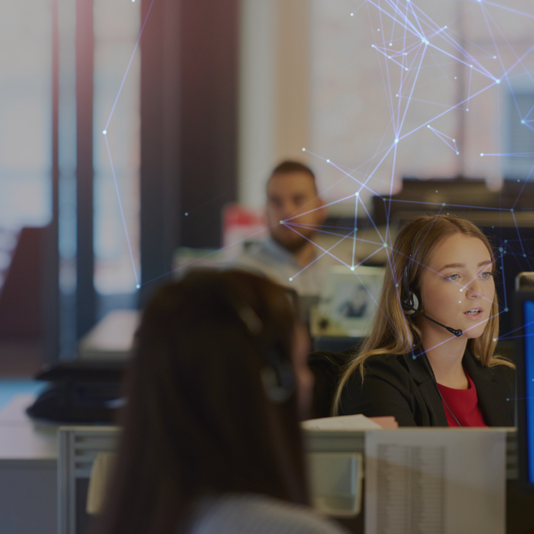 Call centre agents sat at desks, talking on the phone